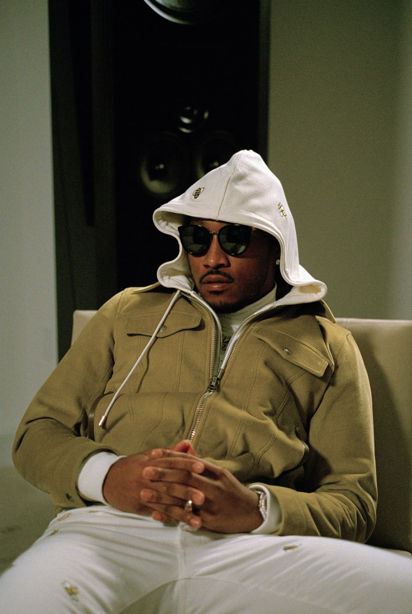 Jordan Bailey leaning back in a chair wearing a hoodie and sunglasses.